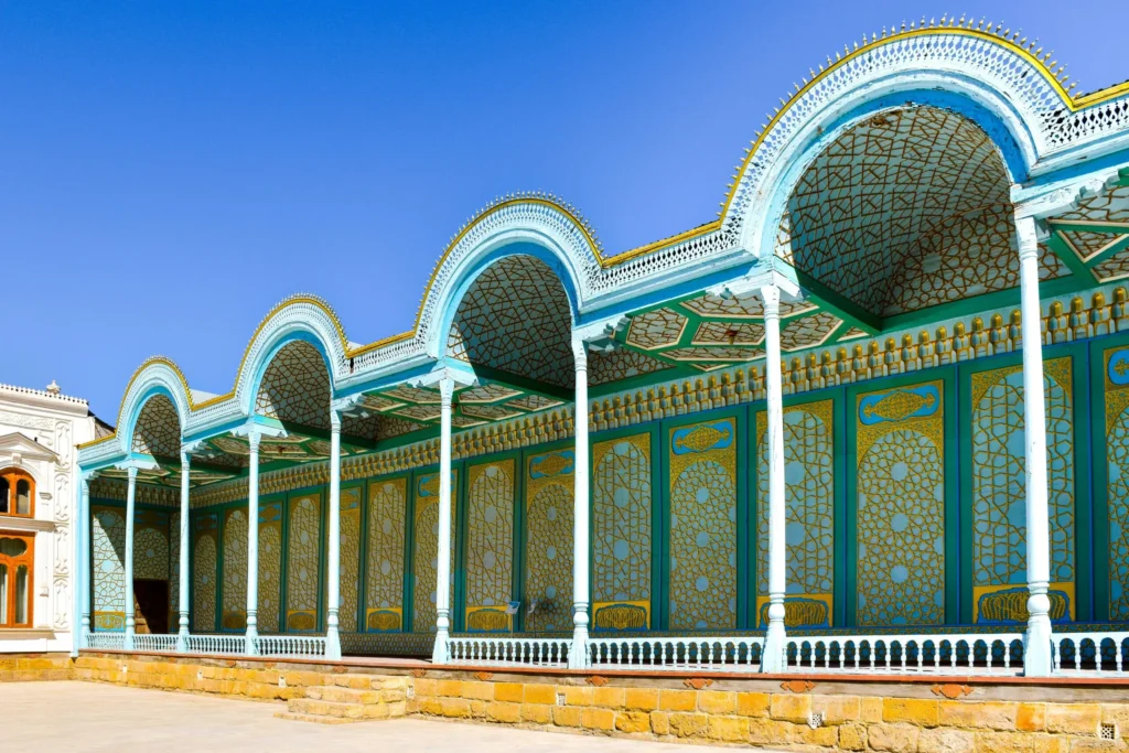 Ornate turquoise and gold building facade with arches and decorative columns.