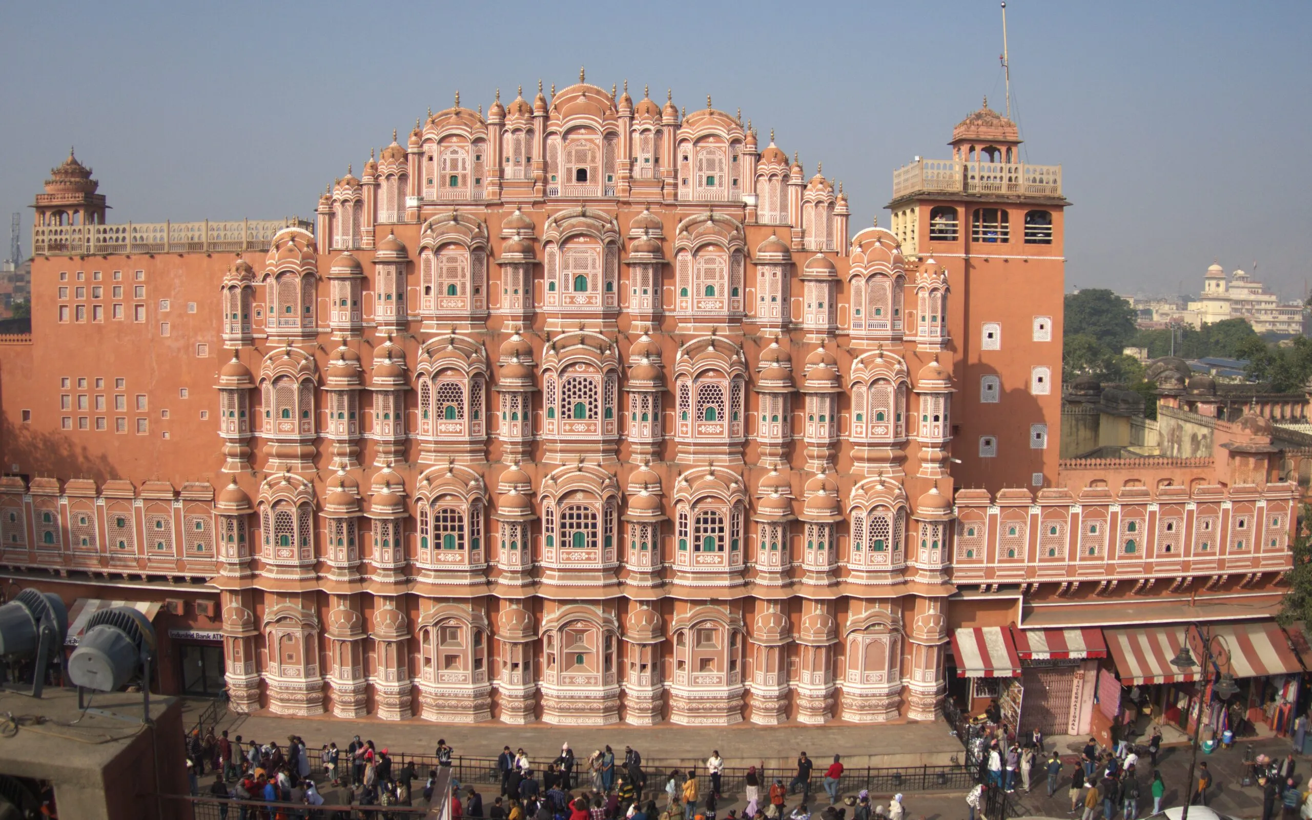 Pink Hawa Mahal Jaipur facade with intricate windows and bustling street"