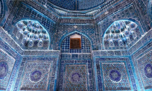 Ornate Islamic architecture with blue tiles, geometric patterns, walls, ceiling, serene design.